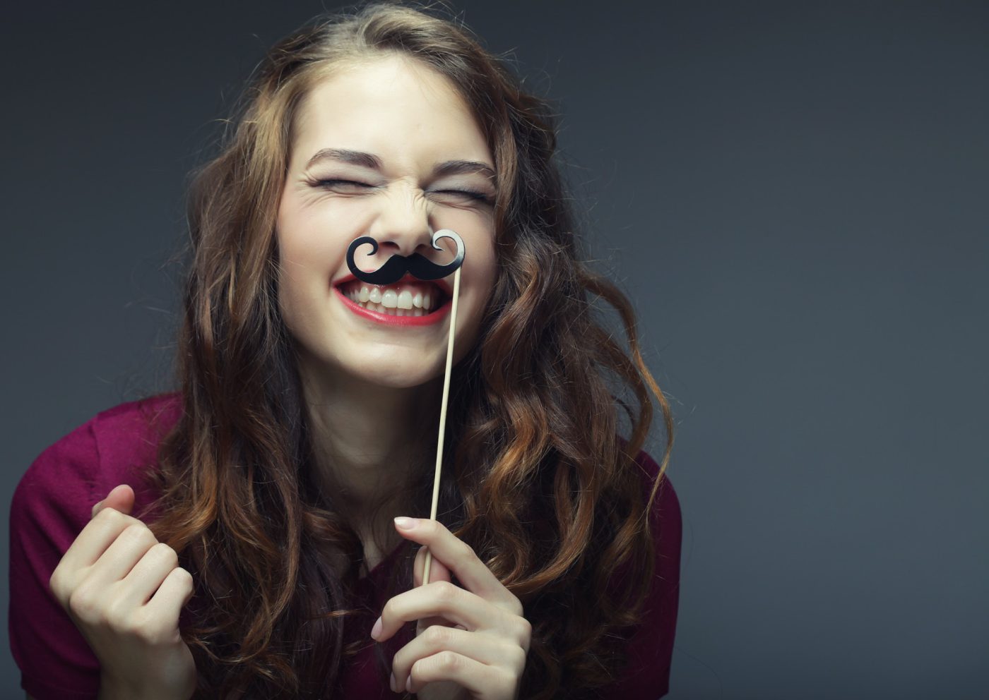 a girl holding a fake moustache